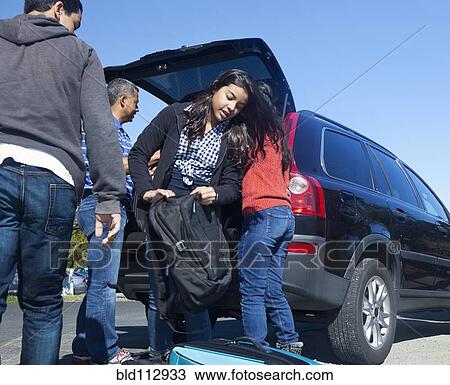 Stock Image - Hispanic family packing up car. Fotosearch