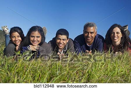 Hispanic family smiling in grass View Large Photo Image Stock Photo - Hispanic family smiling in grass. Fotosearch
