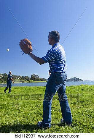 Hispanic father and son playing catch in park View Large Photo Image Stock Photo - Hispanic father and son playing catch in park. Fotosearch