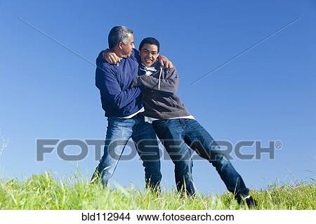 Picture - Hispanic father and son playing in park. Fotosearch