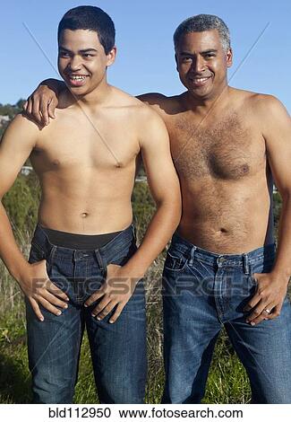 Stock Image - Hispanic father and son standing outdoors. Fotosearch