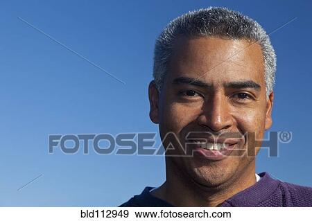 Stock Photo - Hispanic man smiling outdoors. Fotosearch