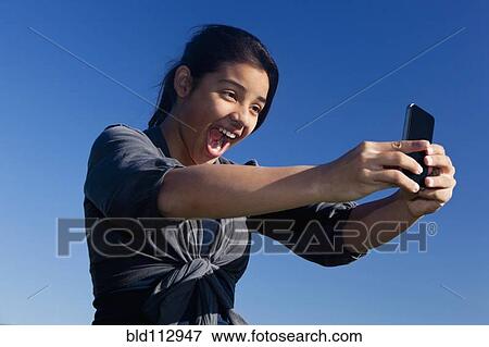 Stock Photo - Hispanic teenage girl taking picture. Fotosearch