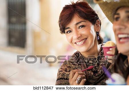 Hispanic woman eating ice cream View Large Photo Image Stock Photo - Hispanic woman eating ice cream. Fotosearch