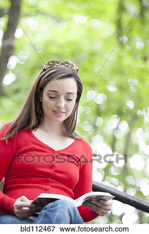 Stock Photo - Hispanic woman reading outdoors. Fotosearch