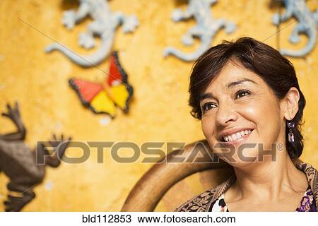 Stock Image - Hispanic woman smiling in chair. Fotosearch