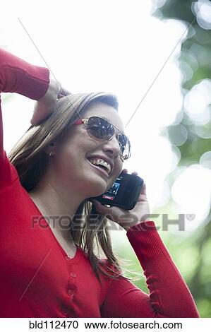 Stock Image - Hispanic woman talking on cell phone. Fotosearch