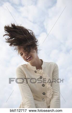 Stock Photo - Mixed race girl flipping hair outdoors. Fotosearch