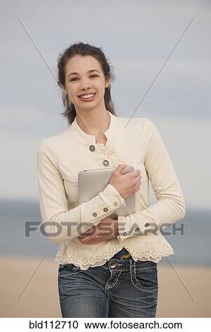 Stock Image - Mixed race girl holding digital tablet. Fotosearch