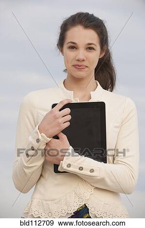 Stock Photo - Mixed race girl holding digital tablet. Fotosearch