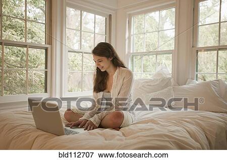 Mixed race girl using laptop in bed View Large Photo Image Stock Photo - Mixed race girl using laptop in bed. Fotosearch