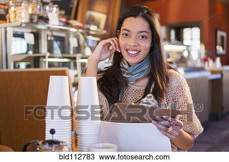 Mixed race woman working in coffee shop View Large Photo Image Stock Image - Mixed race woman working in coffee shop. Fotosearch