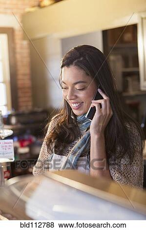 Stock Photo - Mixed race woman working in coffee shop. Fotosearch