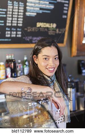 Stock Photo - Mixed race woman working in coffee shop. Fotosearch