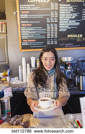 Stock Photograph - Mixed race woman working in coffee shop. Fotosearch