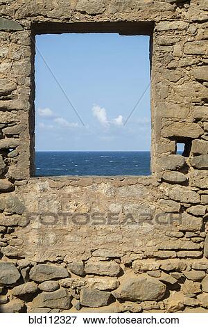 Stock Photo - Ocean viewed through window of stone wall. Fotosearch