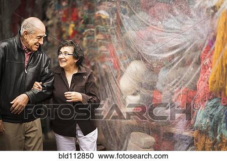 Stock Image - Older Hispanic couple admiring yarn for sale. Fotosearch