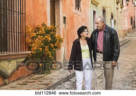 Older Hispanic couple walking on village street View Large Photo Image Stock Photograph - Older Hispanic couple walking on village street. Fotosearch