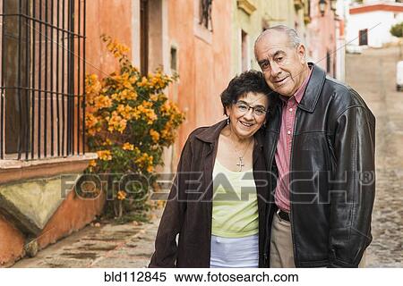Older Hispanic couple walking on village street View Large Photo Image Stock Photography - Older Hispanic couple walking on village street. Fotosearch