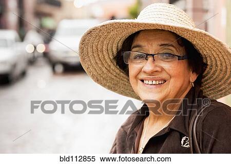 Stock Photography - Older Hispanic woman wearing sunhat. Fotosearch