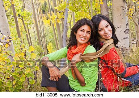 Stock Photography - Smiling friends enjoying forest. Fotosearch