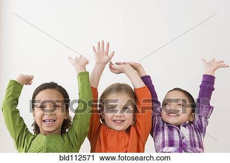 Stock Image - Smiling girls cheering together. Fotosearch