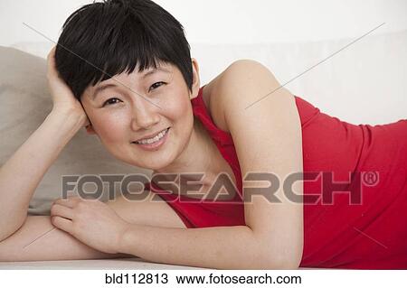 Woman laying on sofa in living room View Large Photo Image Stock Image - Woman laying on sofa in living room. Fotosearch