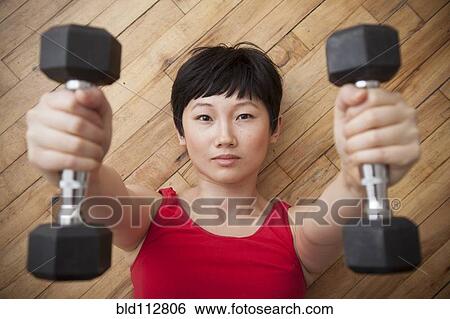 Woman lifting weights on floor View Large Photo Image Stock Photograph - Woman lifting weights on floor. Fotosearch