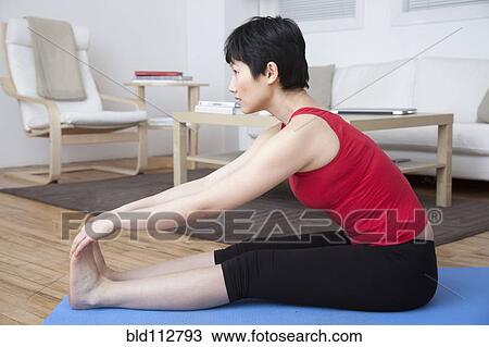 Woman stretching in living room View Large Photo Image Stock Image - Woman stretching in living room. Fotosearch