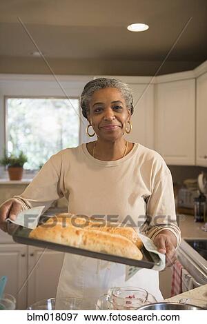 Stock Photo - African American woman baking in kitchen. Fotosearch