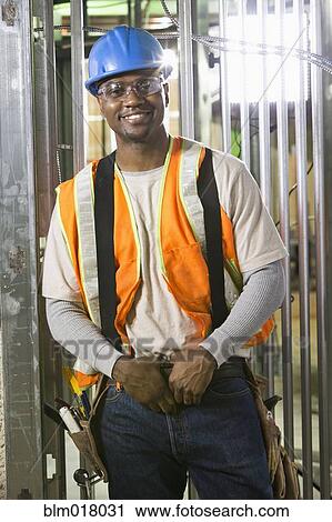 Stock Image - African-American worker smiling on site. Fotosearch