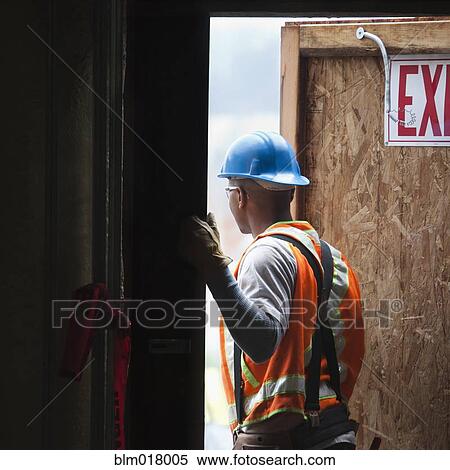 Stock Photography - African American worker standing in doorway. Fotosearch