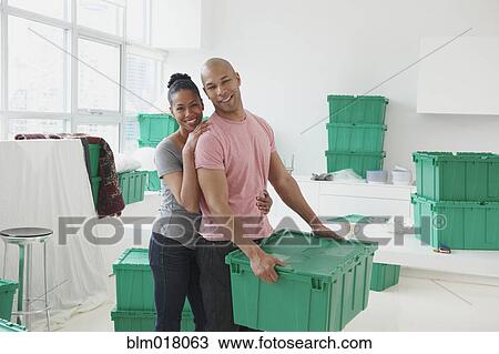 Stock Image - Black couple moving into new house. Fotosearch