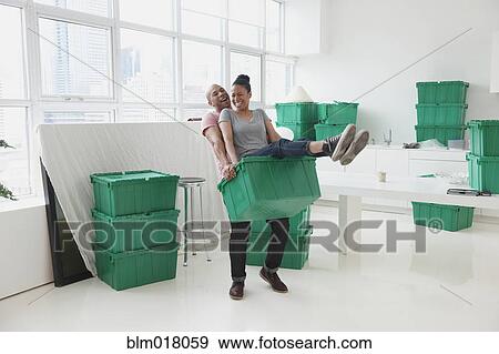 Stock Photo - Black couple moving into new house. Fotosearch
