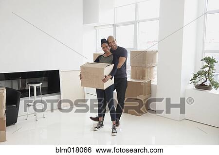 Stock Photograph - Black couple unpacking in new house. Fotosearch
