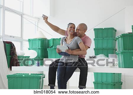 Picture - Black couple using tablet computer in new house. Fotosearch