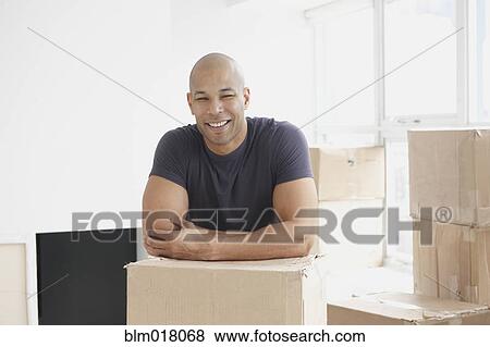 Stock Photo - Black man smiling in new house. Fotosearch