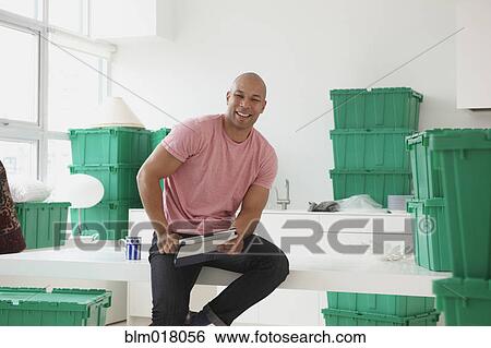 Black man using tablet computer in new house View Large Photo Image Stock Photograph - Black man using tablet computer in new house. Fotosearch
