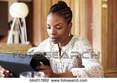 Stock Image - Black woman using tablet computer . Fotosearch