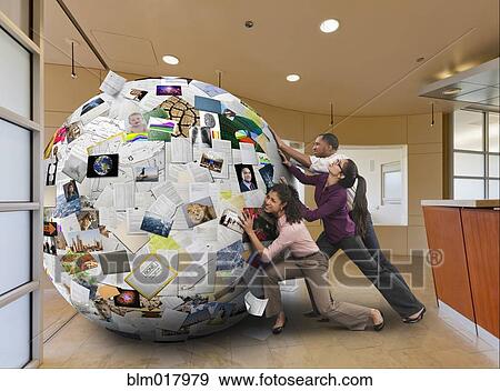 Business people pushing globe of images View Large Photo Image Stock Photo - Business people pushing globe of images. Fotosearch
