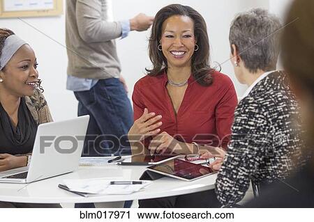 Stock Image - Business people talking in meeting. Fotosearch