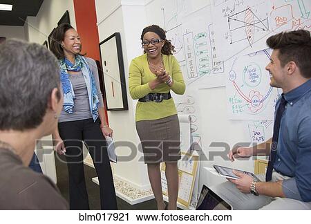 Stock Image - Business people talking in office. Fotosearch