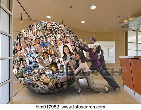 Stock Image - Businesspeople carrying globe on their backs. Fotosearch