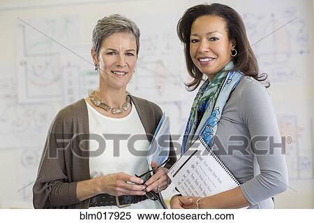Stock Photography - Businesswomen smiling in office. Fotosearch