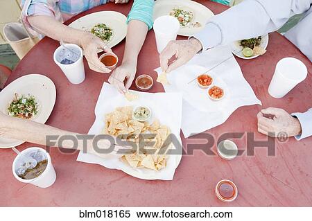 Stock Photography - Caucasian family eating together. Fotosearch