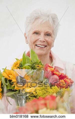 Stock Photo - Caucasian woman holding bouquet of flowers. Fotosearch