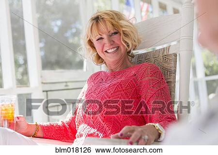 Stock Photograph - Caucasian woman smiling on porch. Fotosearch