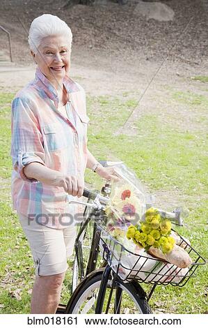 Caucasian woman walking bicycles together View Large Photo Image Stock Image - Caucasian woman walking bicycles together. Fotosearch