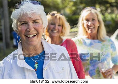 Stock Image - Caucasian women walking on suburban street. Fotosearch