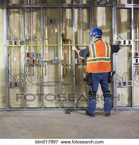 Caucasian worker measuring metal on site View Large Photo Image Stock Photo - Caucasian worker measuring metal on site. Fotosearch